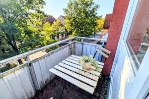 a wooden bench sitting on a balcony at Uhlpartment - im Herzen von Munster in Munster im Heidekreis