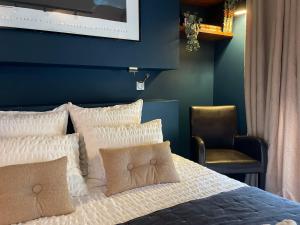 a bedroom with a bed with a blue wall at Yanna Lodge, gîte classé 4 étoiles avec Spa couvert entièrement in Arrest +19 photos