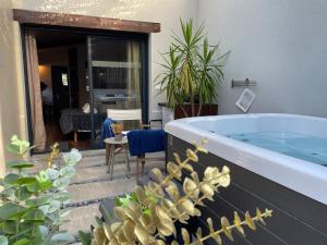 a bath tub in a room with plants at Yanna Lodge, gîte classé 4 étoiles avec Spa couvert entièrement in Arrest