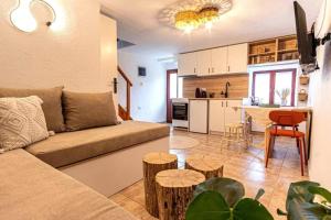 a living room with a couch and a table and a kitchen at Samora Guest House in Samothraki