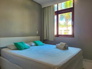 a bedroom with a large bed with a window at Maraca Beach Beira-mar in Porto De Galinhas