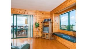 a room with a television and a table with a dining room at Wine Downtime - Mangawhai Holiday Home in Mangawhai