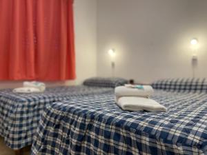 two beds with towels on top of them in a room at Hostel Danny in El Calafate