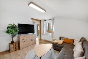a living room with a couch and a flat screen tv at FeWo-Hacke in Halblech