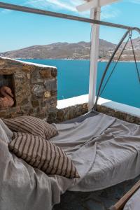 a bed in a room with a view of the water at Astrio Suites in Livadi