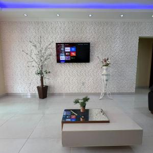 a living room with a tv on a wall at Arraial do cabo alohacasasdetemporada in Arraial do Cabo