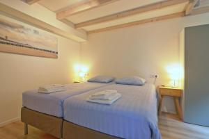 a bedroom with a bed with two towels on it at NIEUW! Vakantiehuis Singel 3A met SAUNA - baddomburg in Domburg