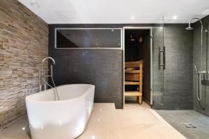 a bathroom with a tub and a glass shower at Grand Villa Kataja in Rovaniemi +26 photos