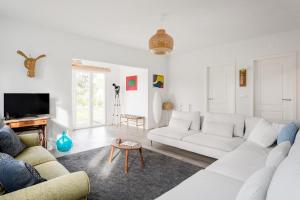 a white living room with a white couch and a table at Pinhal da Praia em Melides in Quinta da Cascalheirinha