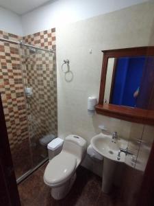 a bathroom with a toilet and a sink and a shower at Hotel Emperador in Jamundí