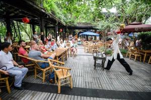 a man is playing a game in front of a crowd at Chengdu city center Tianfu Square Kuanzhai Alley People's Park subway post-modern design 85 square meters 2 bedrooms 1 living room design B&B HD cinema family suite in Chengdu