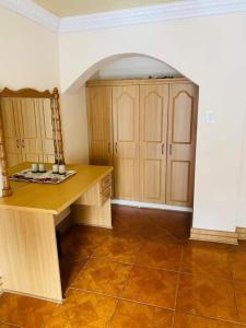 a kitchen with a wooden desk and wooden cabinets at THE HAVEN GUEST HOUSE NKOYOYO in Mbabane