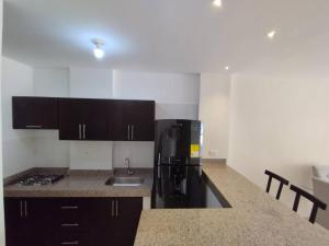 a kitchen with a black refrigerator and a sink at Edificio Verona 57 - Apartamento en Piedecuesta in Piedecuesta