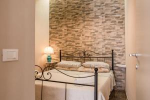 sypialnia z łóżkiem i ceglaną ścianą w obiekcie La casa di Adina w mieście Agrigento