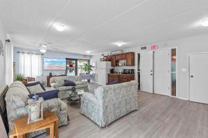 Una sala de estar con dos sofás y una cocina. en Ocean Terrace Club 601, en Daytona Beach Shores