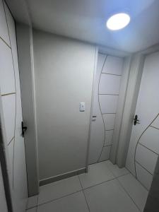 a hallway with a white door and a light at ACONCHEGANTE Aptº NA PRAIA DE OLINDA in Olinda +1 photo