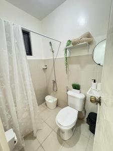 a bathroom with a toilet and a shower curtain at Cozy Escape Calaca in Calaca +11 photos