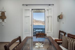 a living room with a table and a view of the ocean at Astrio Suites in Livadi