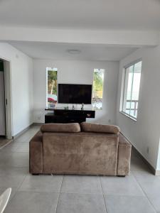 a living room with a couch and a flat screen tv at Casa Paraíso Bananal - Iha Grande - Angra Dos Reis in Angra dos Reis