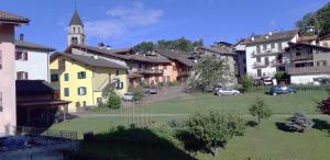 a group of buildings in a town with a church at Appartamento EDELWEISS in Baselga di Pinè