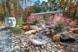 a garden with a statue of a face on the ground at Full Bloom Tree House in Pittsboro