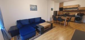 a living room with a blue couch and a table at South Mountain Apartment in Razlog