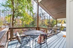 a patio with a table and chairs on a deck at Two Tree Houses - Galaxy & Full Bloom in Pittsboro