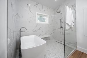 a white bathroom with a shower and a sink at Two Tree Houses - Galaxy & Full Bloom in Pittsboro