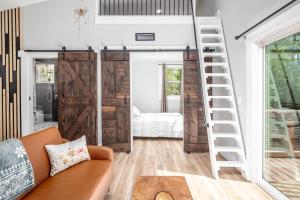 a living room with a loft bed and a ladder at Elevate Tree House Community in Pittsboro