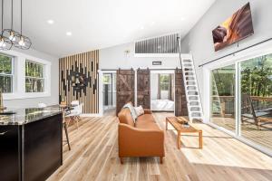 a living room with a staircase and a couch at Elevate Tree House Community in Pittsboro