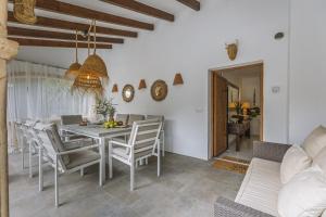 une salle à manger avec une table et des chaises blanches dans l'établissement Villa Artista, à Jávea