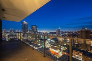 a view of a city skyline at night from a balcony at Poolside Bliss In the Heart of Downtown! 22 FL w Tower Views! FREE Banff Pass, Gym, Wine, Parking, Summer Outdoor Pool! in Calgary
