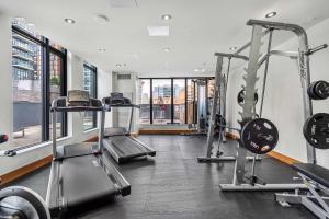 a gym with two treadmills and two machines at Poolside Bliss In the Heart of Downtown! 22 FL w Tower Views! FREE Banff Pass, Gym, Wine, Parking, Summer Outdoor Pool! in Calgary