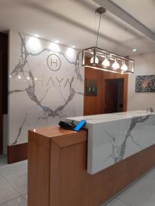 a lobby with a reception counter with a marble wall at Haya Hotel And Spa in Tabarja +127 photos