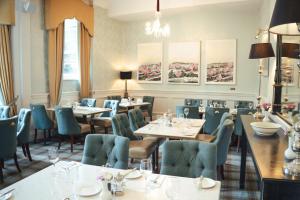 restauracja ze stołami i krzesłami w pokoju w obiekcie Old Ground Hotel w mieście Ennis