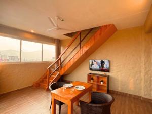 博卡拉Nishan Apartments -Lakeside的客房设有木桌和楼梯。