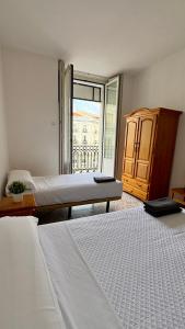 a bedroom with two beds and a large window at Hostal Ruano in Madrid +55 photos
