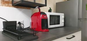 a red mixer sitting on a counter next to a microwave at C'era una volta in Modugno