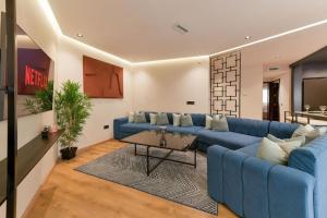 a living room with a blue couch and a table at Sky Blue Suite - Terrace & Ocean View 2BR in Tangier