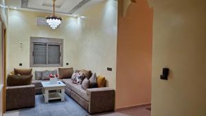 a living room with a couch and a table at Merzouga luxury Stay in Merzouga +3 photos