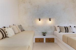 two beds in a room with white walls at Arch Chora Home next to the Old Castle in Naxos Chora