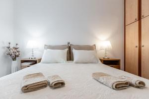 une chambre avec un lit blanc avec des serviettes dessus dans l'établissement Diamond of Naxos -Chora-, à Naxos Chora