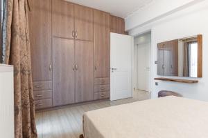 - une chambre avec des placards en bois, un lit et un miroir dans l'établissement Diamond of Naxos -Chora-, à Naxos Chora