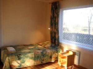 - une chambre avec un lit et une grande fenêtre dans l'établissement Piiri Holiday House, à Otepää