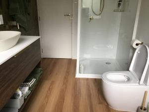 a white bathroom with a toilet and a sink at Self contained and private room in Dunedin