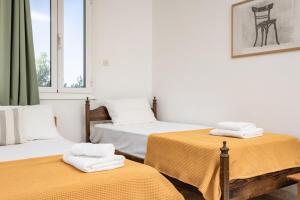 two beds with towels on them in a room at Marathitis cottage house - Aegean sea view in Kanakis