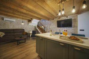 a kitchen and living room with a couch and a table at Villa Dalmatina Charming stone house with pool, 40 m from see in Tribunj