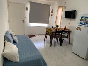 a living room with a table and a bed at Casita María in Puerto San Julián