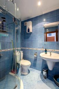 a blue tiled bathroom with a toilet and a sink at One Bedroom Apartment Pirin Lodge in Bansko +45 photos