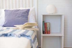 a bed with a book shelf next to a bed at Apiliotis sunrise beach villa in Ligaridia